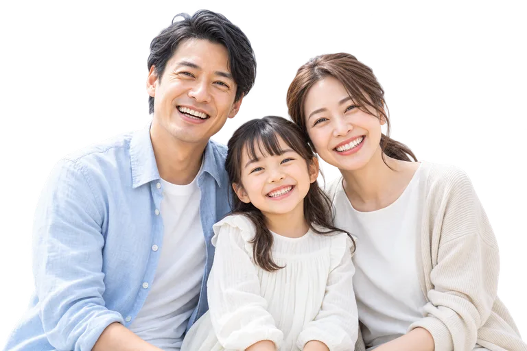 淡い空と住宅を背景に、笑顔で寄り添う親子のイメージ